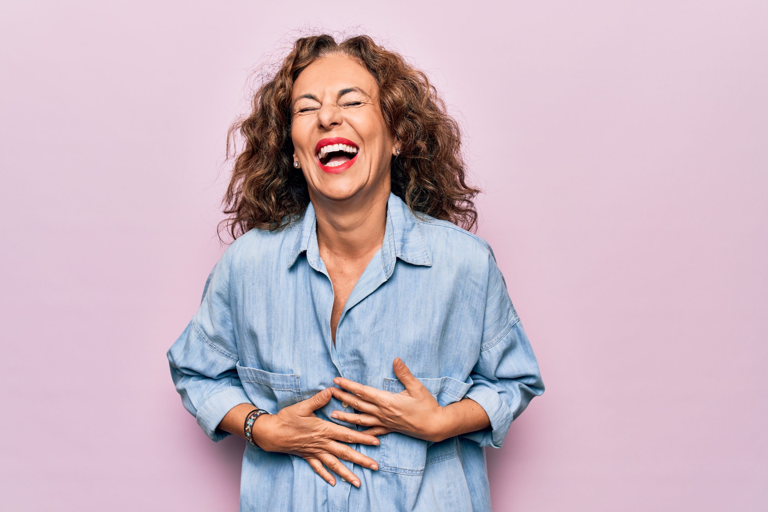 Woman grasping her stomach and laughing hysterically